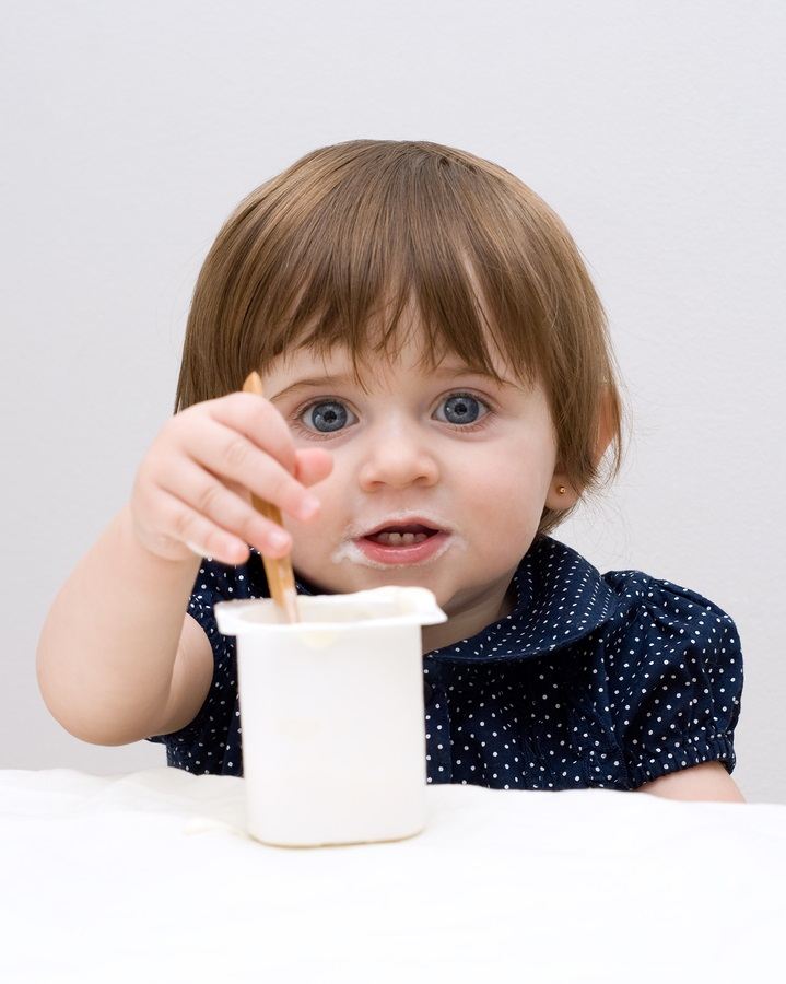 Portrait of the little girl with yogurt