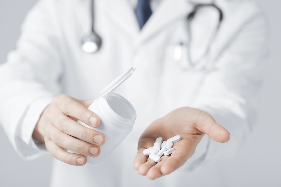 picture of doctor hands holding white pack and pills