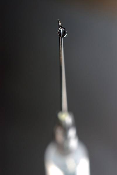 syringe close-up, focus on the drop