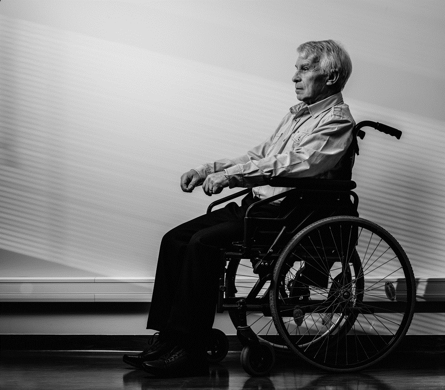 Thoughtful senior man in wheelchair in nursing home