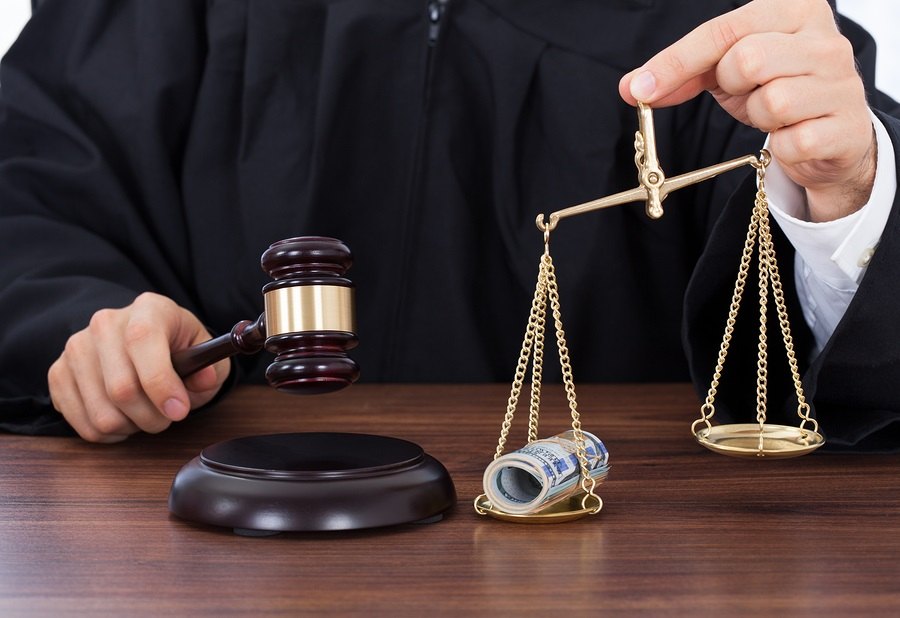 Judge Striking Gavel While Holding Scale With Money