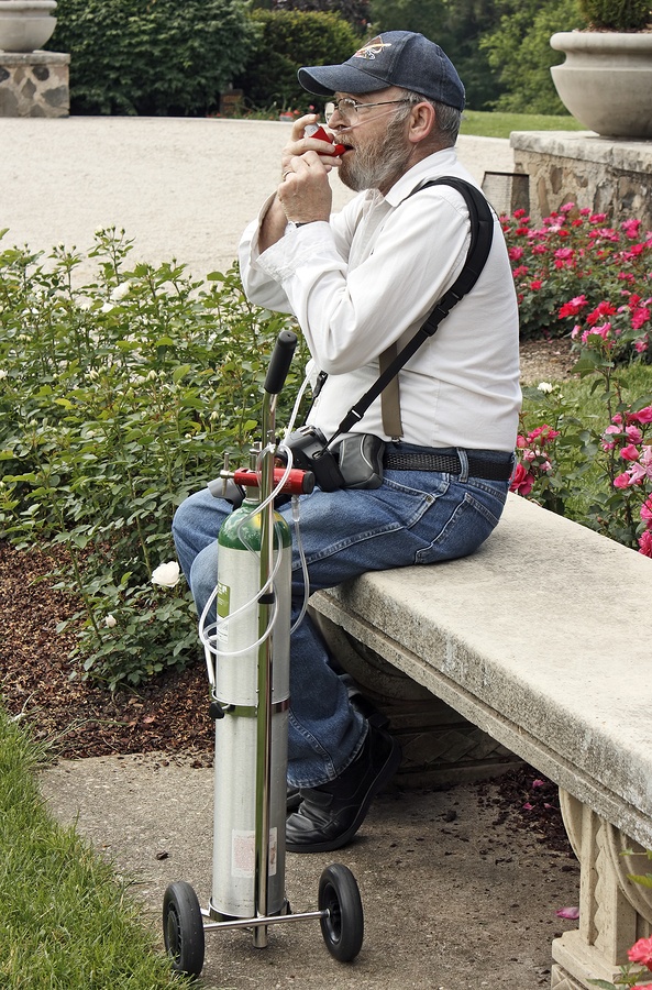 Disabled man. His life depends on his oxygen tank. Asthma emphysema COPD. He is using a rescue inhaler.