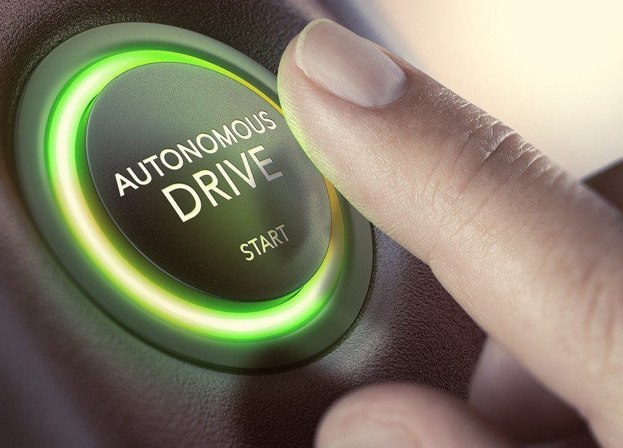 Finger pressing a push button to start a self-driving car. 