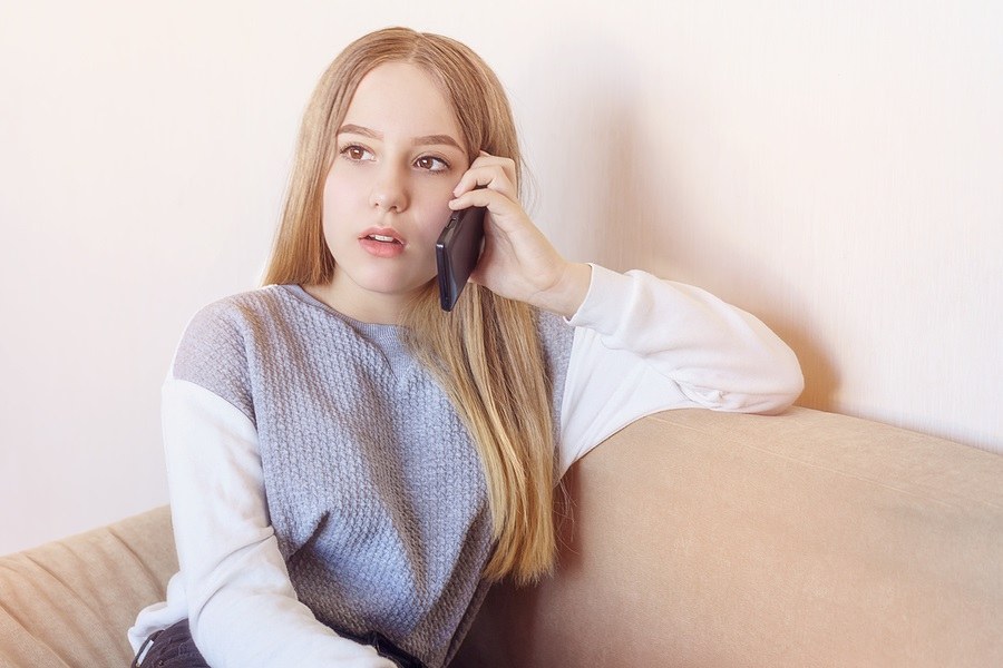 Teen girl holding a phone near her ear