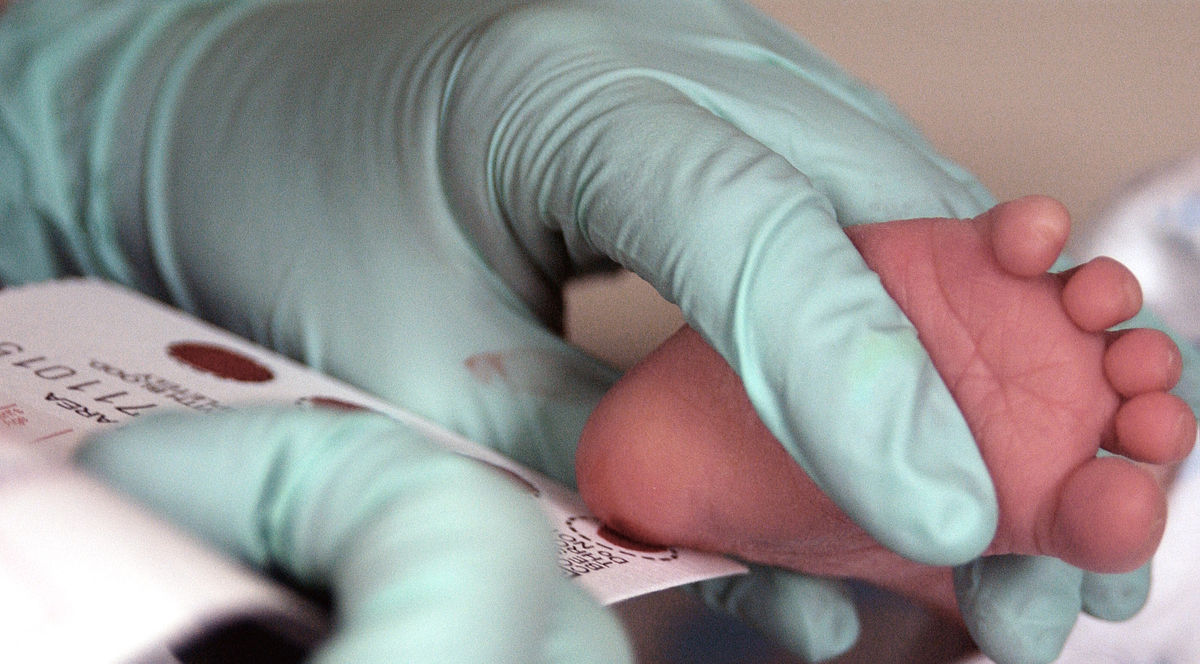 Photo of infant heel prick for blood sample.