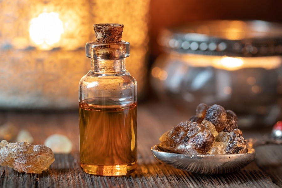 A bottle of essential oil with frankincense resin crystals