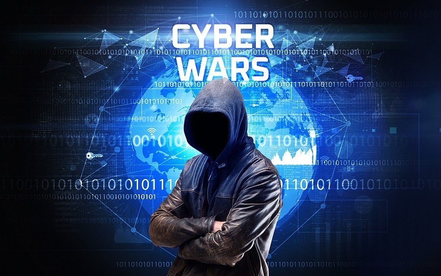 Faceless hacker at work with CYBER WARS inscription, Computer se