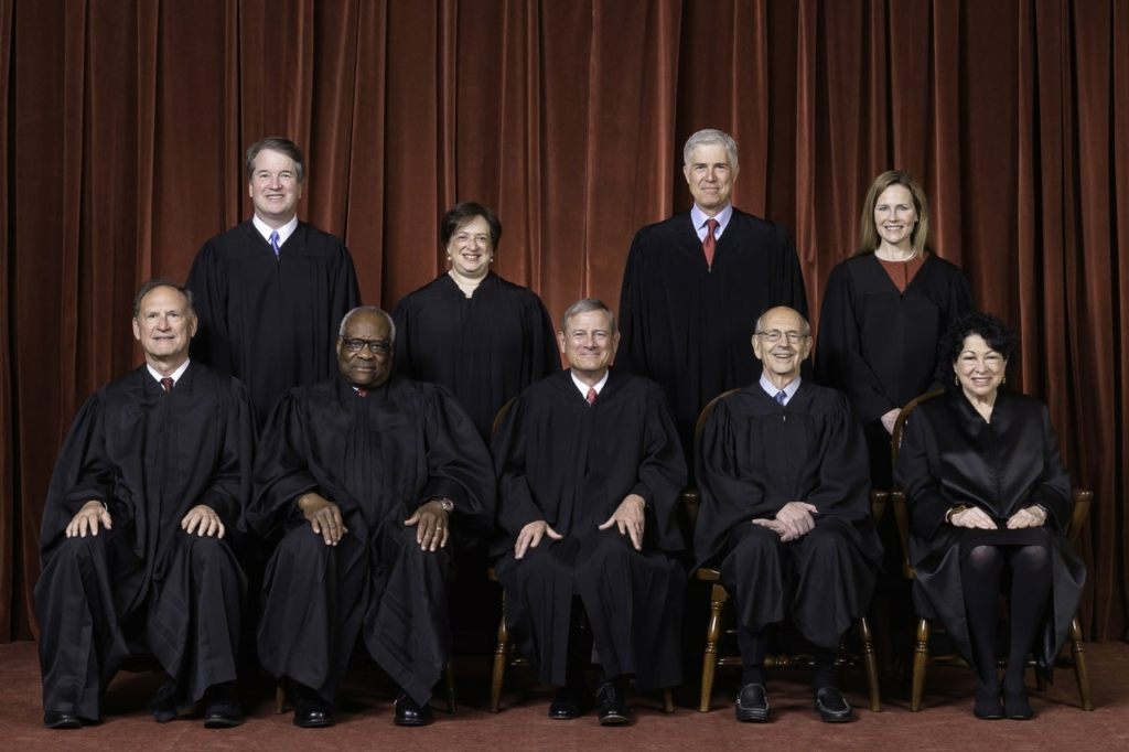 The Roberts Court, April 23, 2021  .Seated from left to right: Justices Samuel A. Alito, Jr. and Clarence Thomas, Chief Justice John G. Roberts, Jr., and Justices Stephen G. Breyer and Sonia Sotomayor  .Standing from left to right: Justices Brett M. Kavanaugh, Elena Kagan, Neil M. Gorsuch, and Amy Coney Barrett.  .Photograph by Fred Schilling, Collection of the Supreme Court of the United States