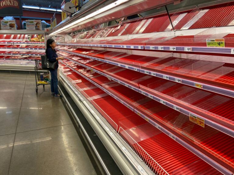 A shopper picks over the few items remaining in the meat section, as people stock up on supplies amid coronavirus fears, at an Austin, Texas
